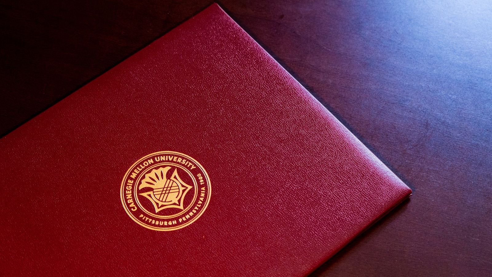 red and gold book on black textile