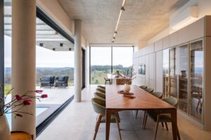 Modern dining room with expansive windows and scenic view.