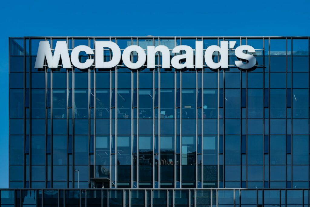 A tall glass building with a mcdonald's sign on it