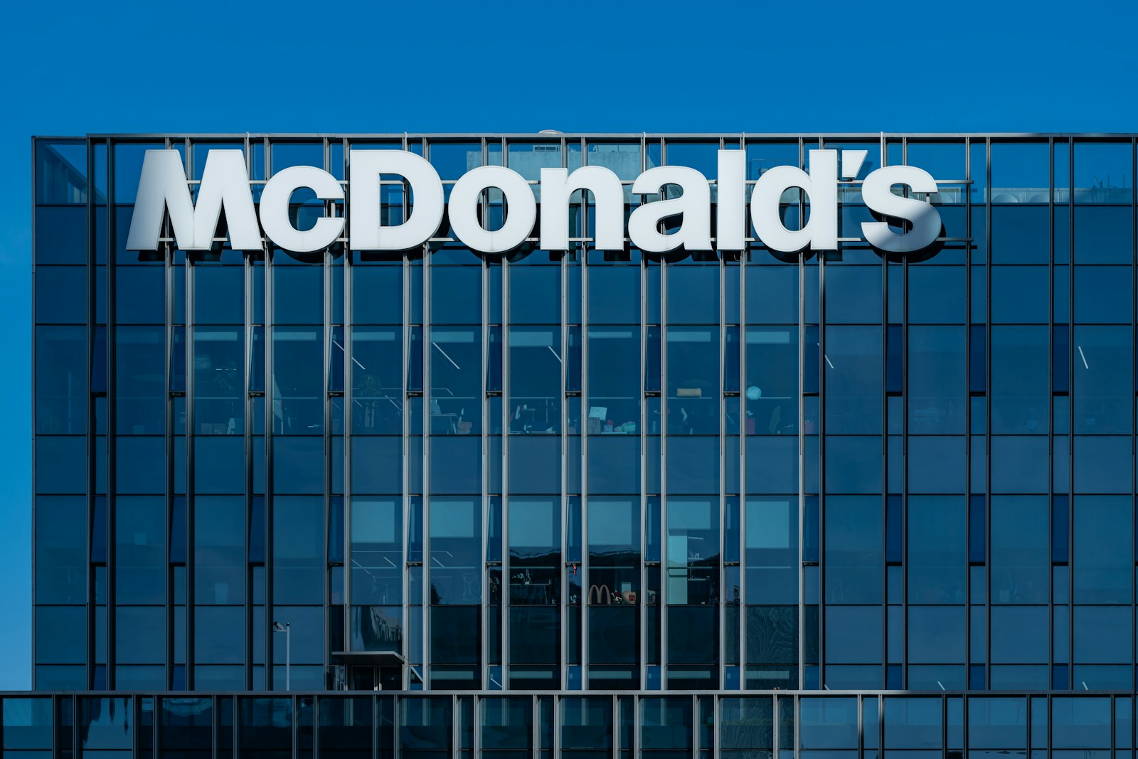 A tall glass building with a mcdonald's sign on it