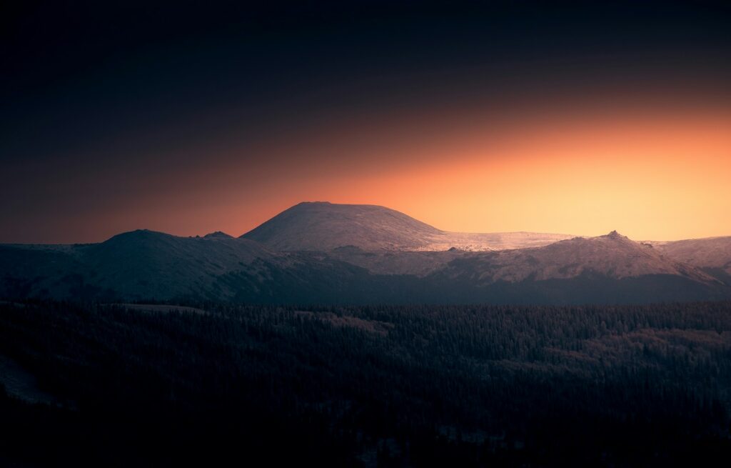 Mountain silhouette against a vibrant sunset sky.