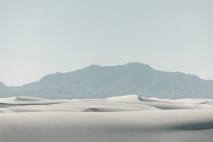 White sand dunes with a distant mountain range.
