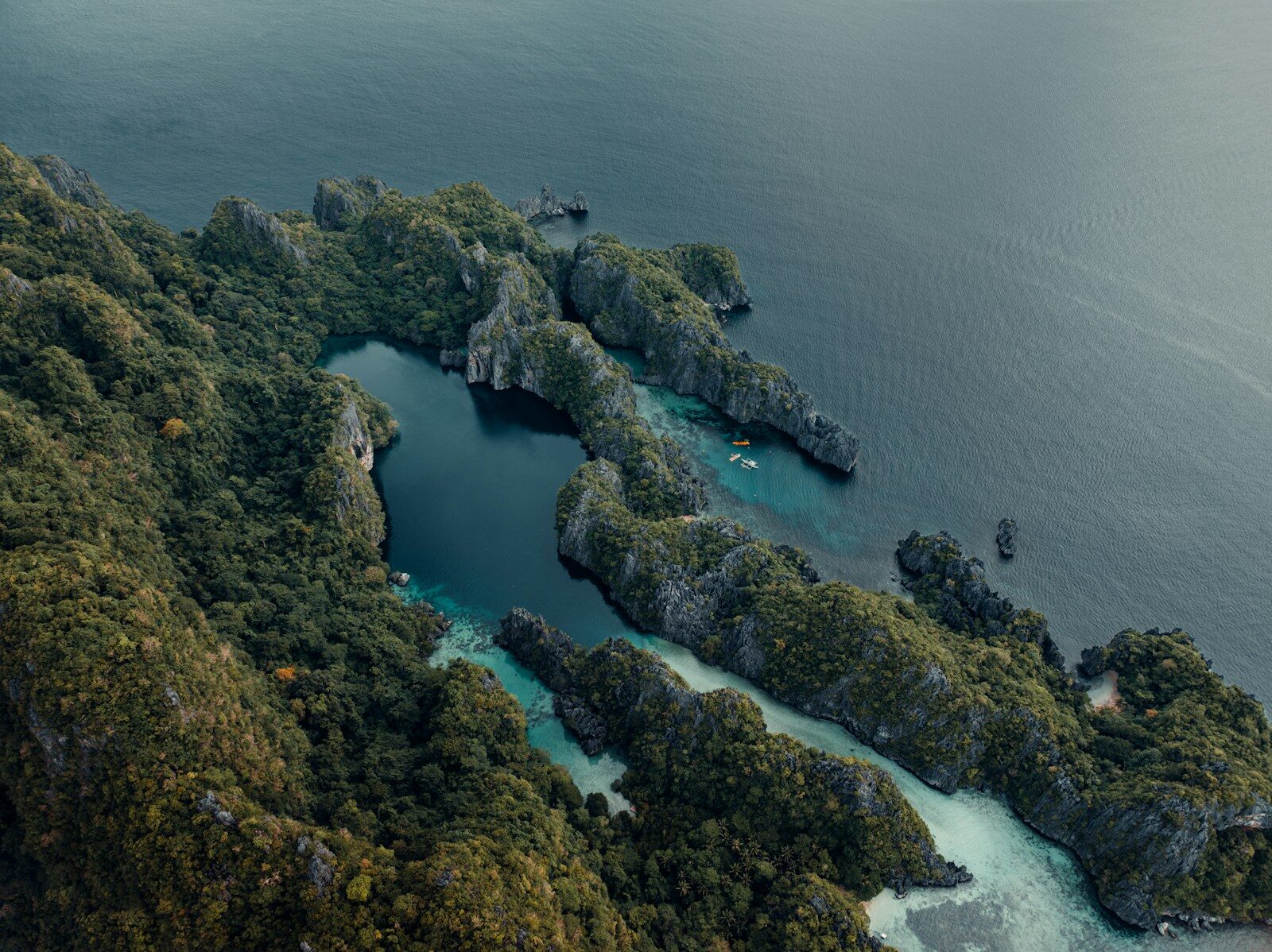 Jagged islands covered in lush green vegetation in the ocean.